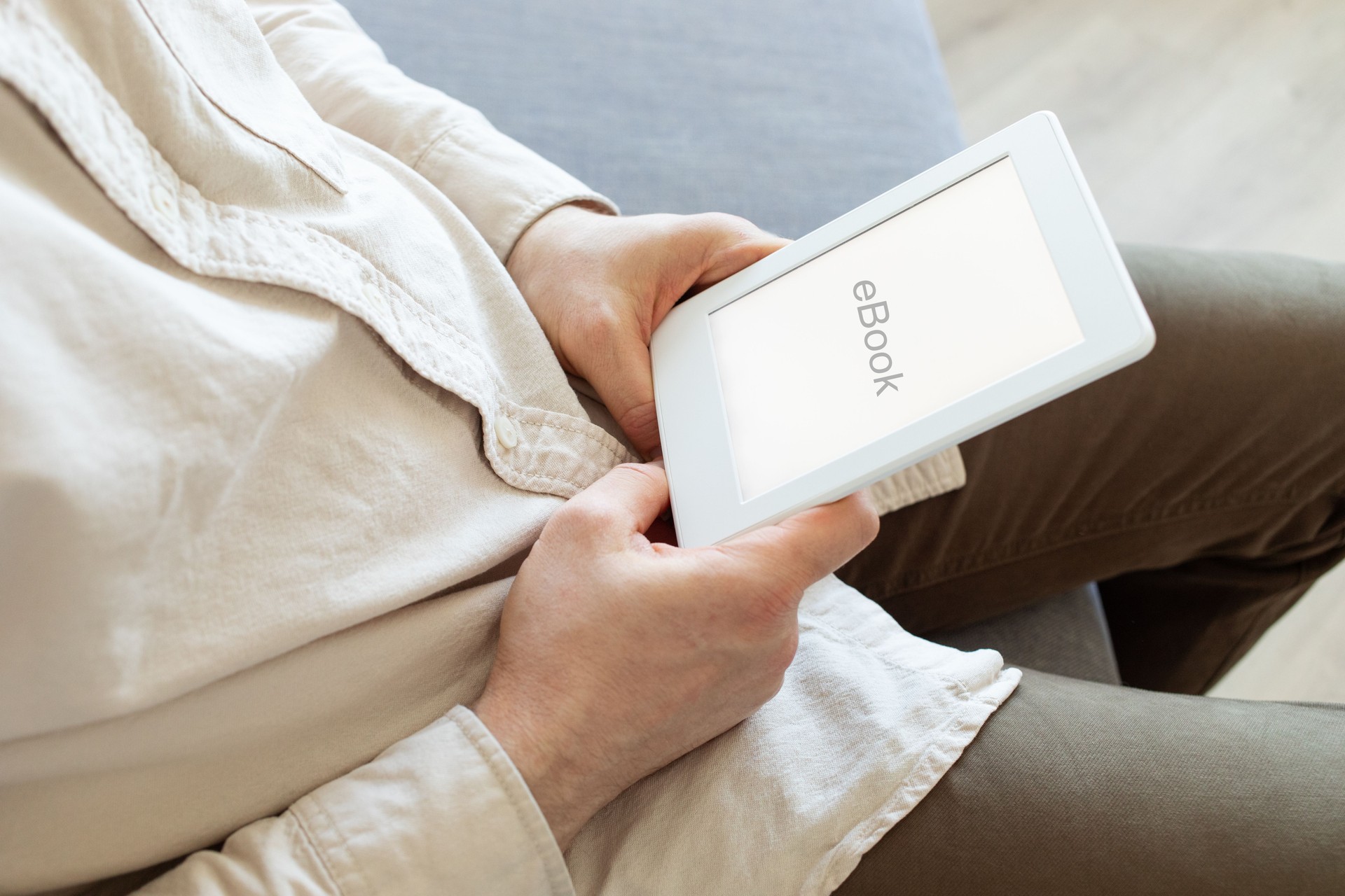 Man reading ebook. Modern digital e-book tablet with electronic ink technology for relaxation, education and business.